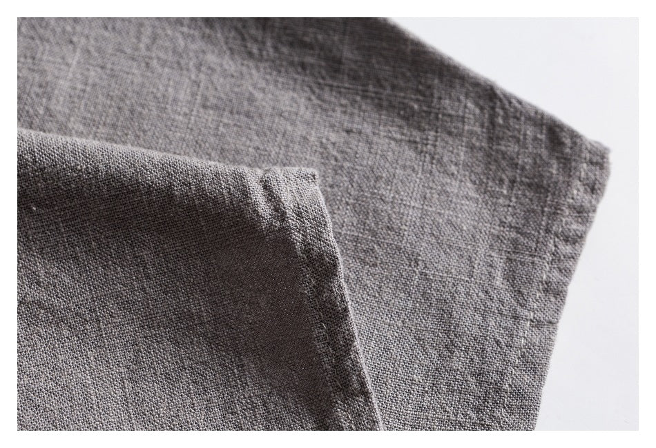 Close-up of the folded edge and stitching on a gray shirt sleeve.