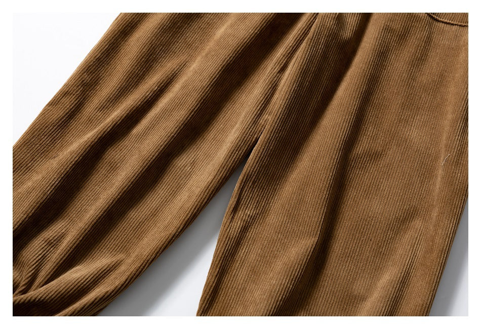 Close-up of the legs of brown corduroy pants, highlighting the raised vertical ridges.
