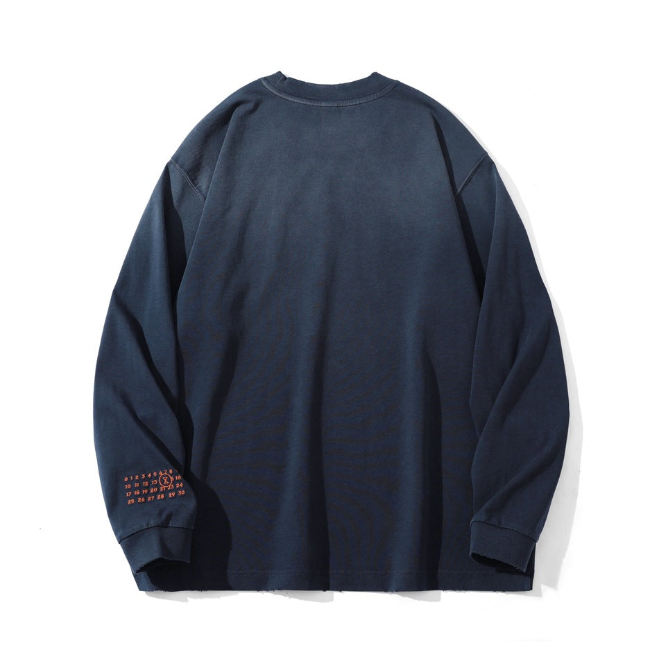 Back view of a navy long-sleeve shirt laid flat, with a small orange graphic near one cuff.