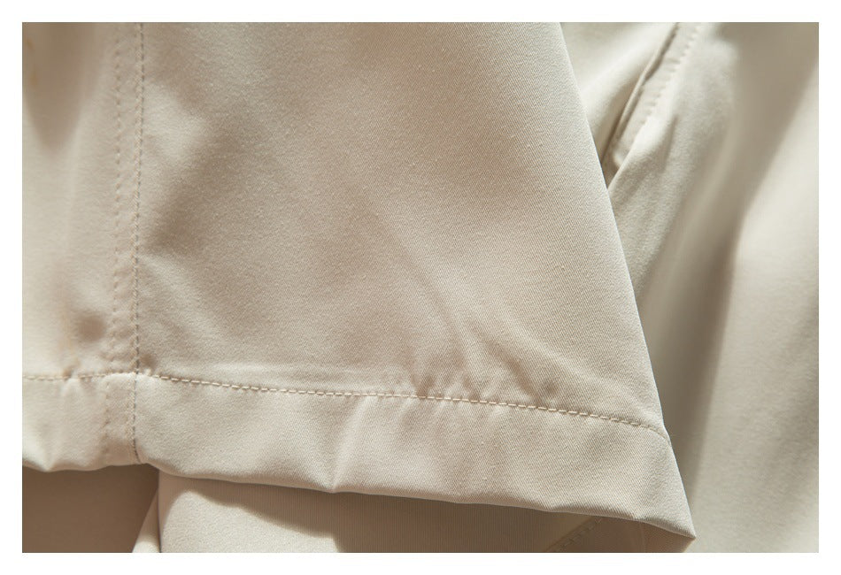 Close-up of a beige shorts leg seam and stitched hem.