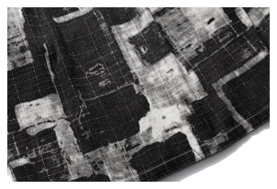 Close-up showing the black-and-gray abstract print and rows of stitching on a garment.