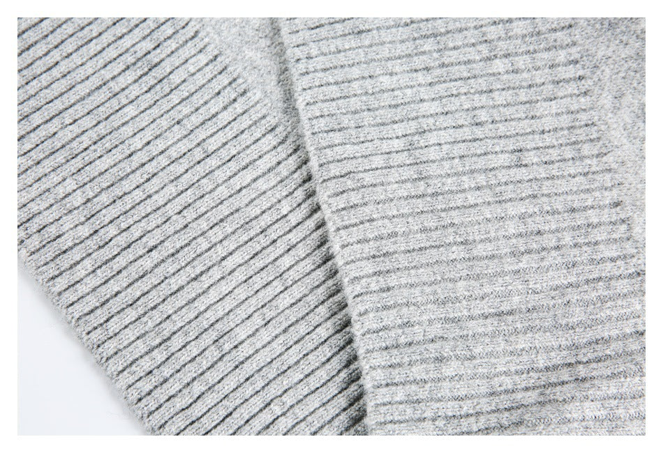 Close-up of two light gray ribbed knit sections meeting at a seam.