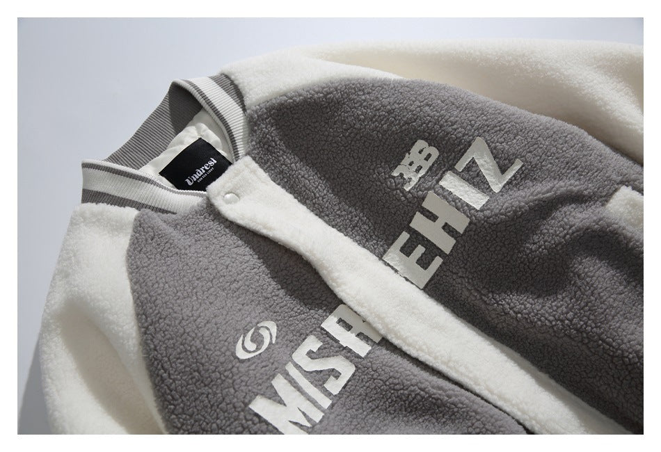 Close-up of the gray-and-cream jacket front, showing chest lettering, snap placket and striped collar.