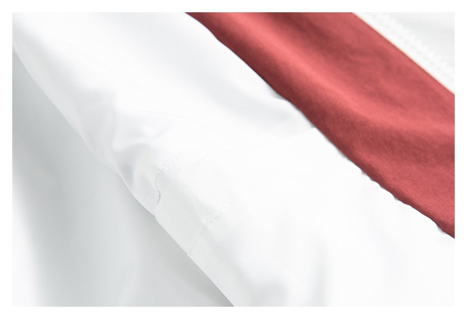 Close-up of a white garment seam beside a burgundy fabric panel.