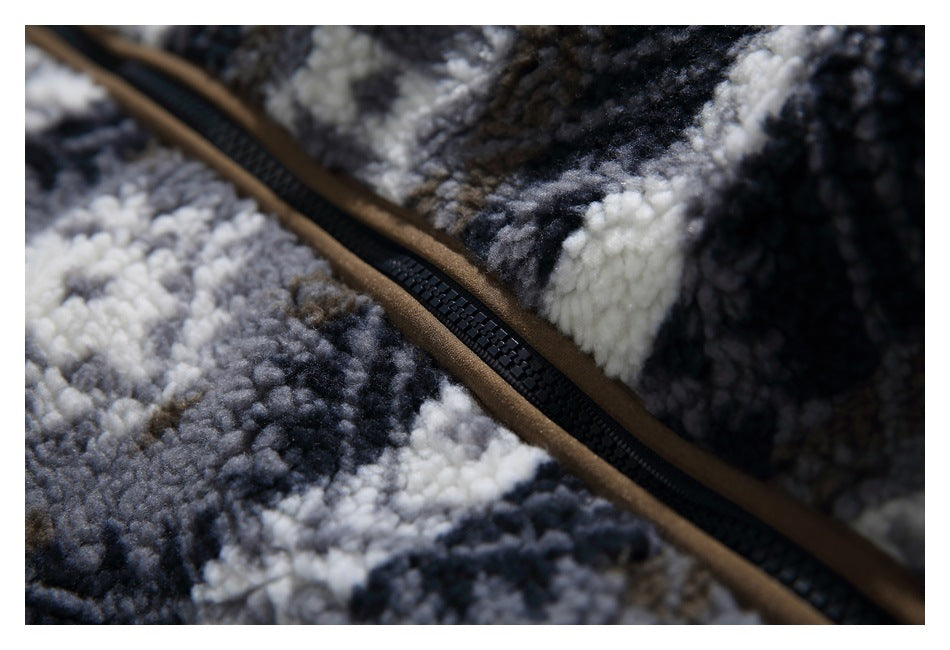 Close-up of a black zipper and brown trim against the jacket's gray, black, and cream fleece pattern.