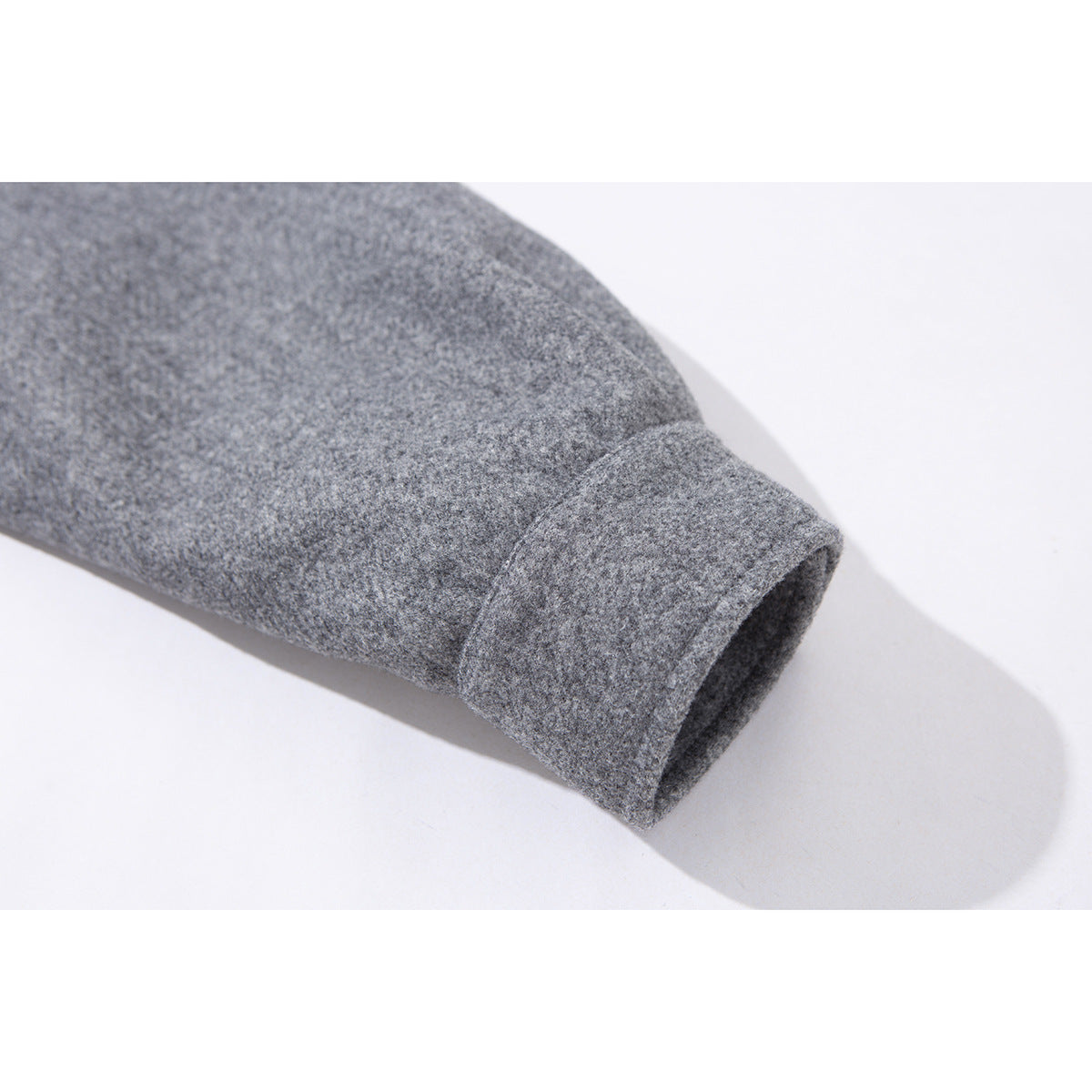 Close-up of a gray jacket sleeve ending in a simple folded cuff.