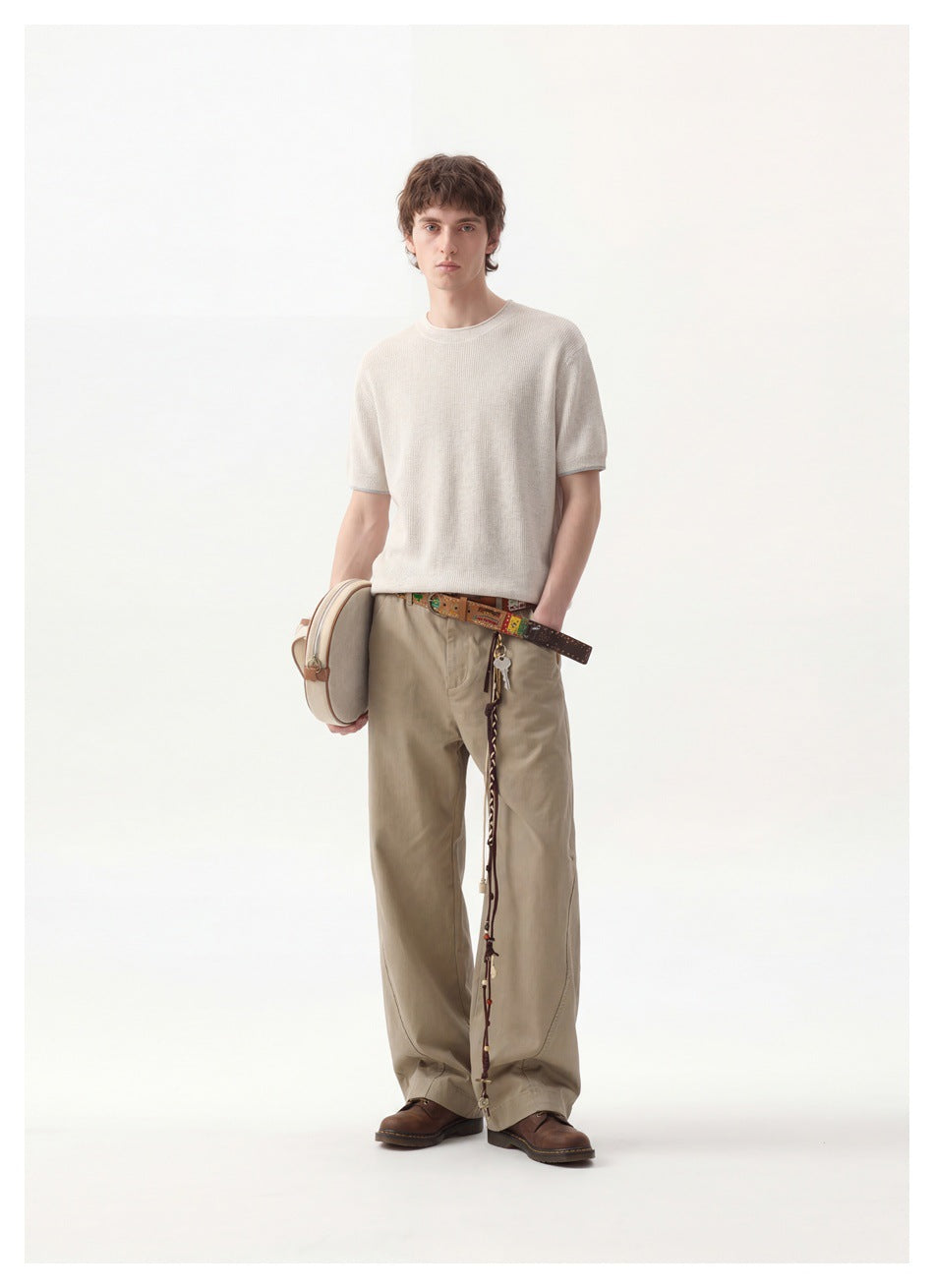 Full-length front view of a model wearing an off-white ribbed short-sleeve crewneck top and khaki trousers.
