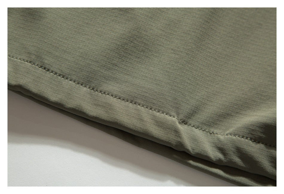 Close-up of the olive khaki garment hem and its double stitching.