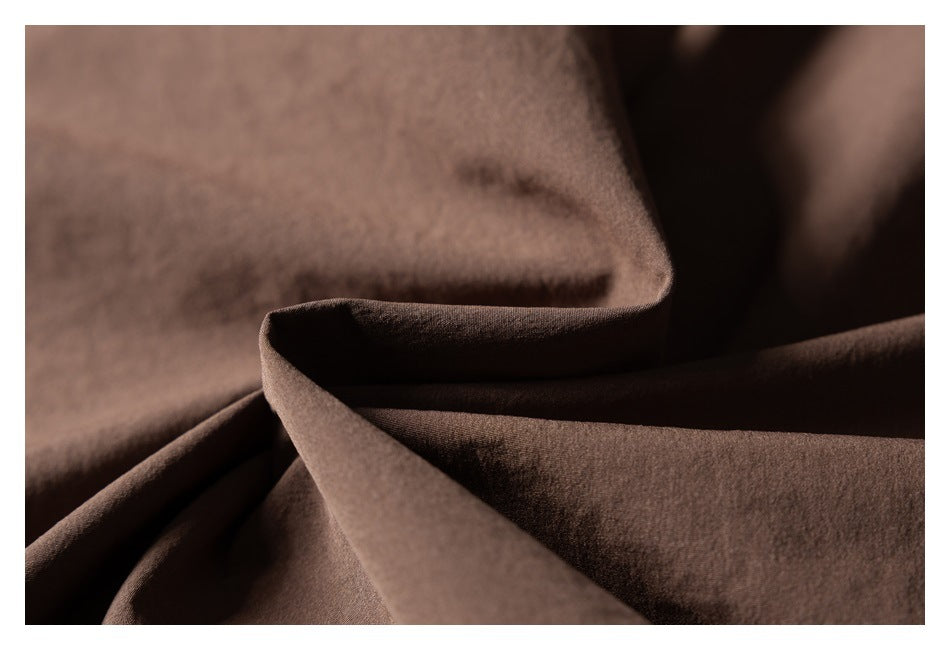 Close-up of softly folded brown fabric showing its matte, fine-textured surface.