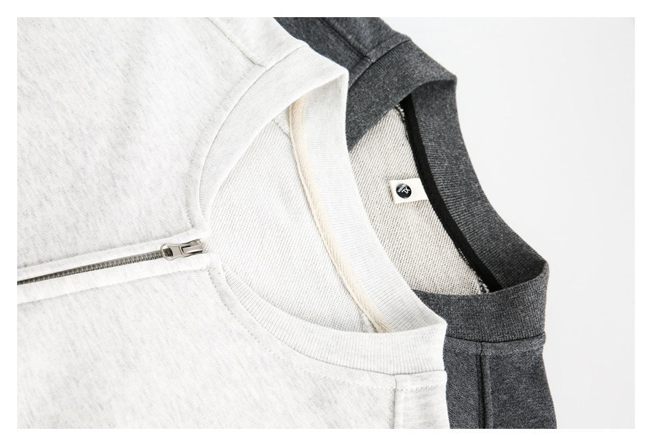 Close-up of crewneck collars and zipper on light gray and charcoal sweatshirts.