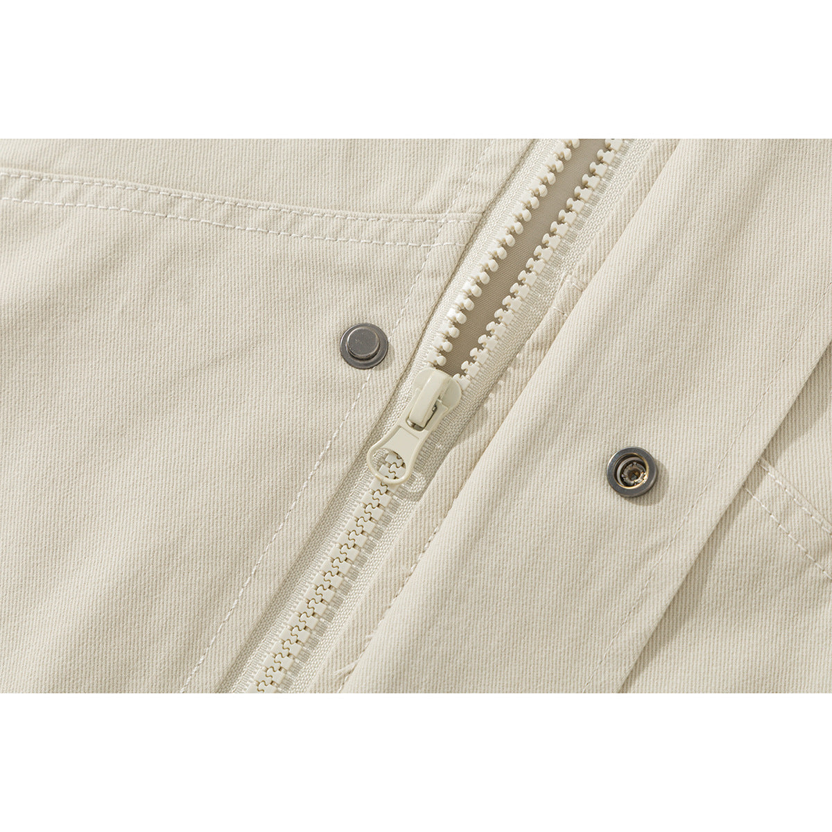 Close-up of the ivory jacket's front zipper, snap fasteners, and stitched placket.
