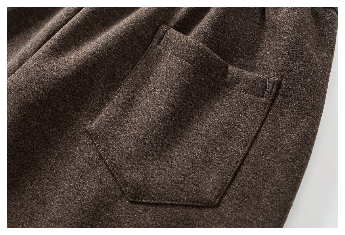 Close-up of a dark brown garment with a large stitched patch pocket.