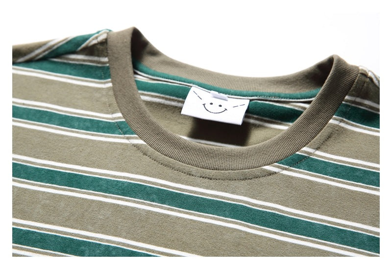 Close-up of the khaki ribbed crew neck and striped fabric, with a small smiley-face tag inside.