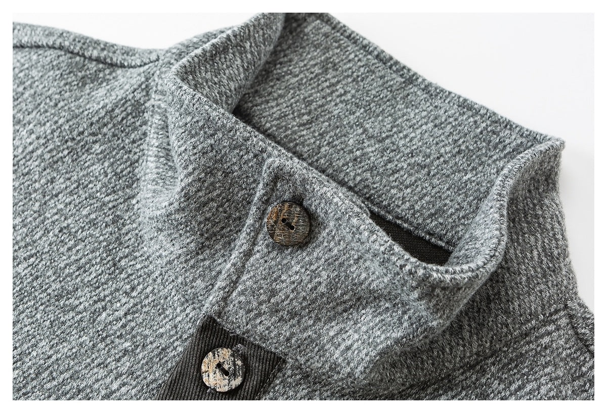 Close-up of a gray textured garment collar with a dark inner facing and two mottled brown buttons.