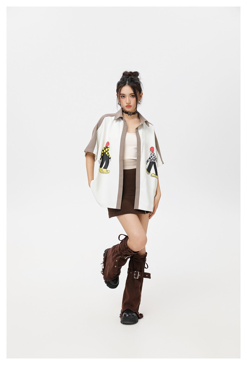 Model posing in the open color-block printed shirt with a brown skirt and brown buckled leg warmers