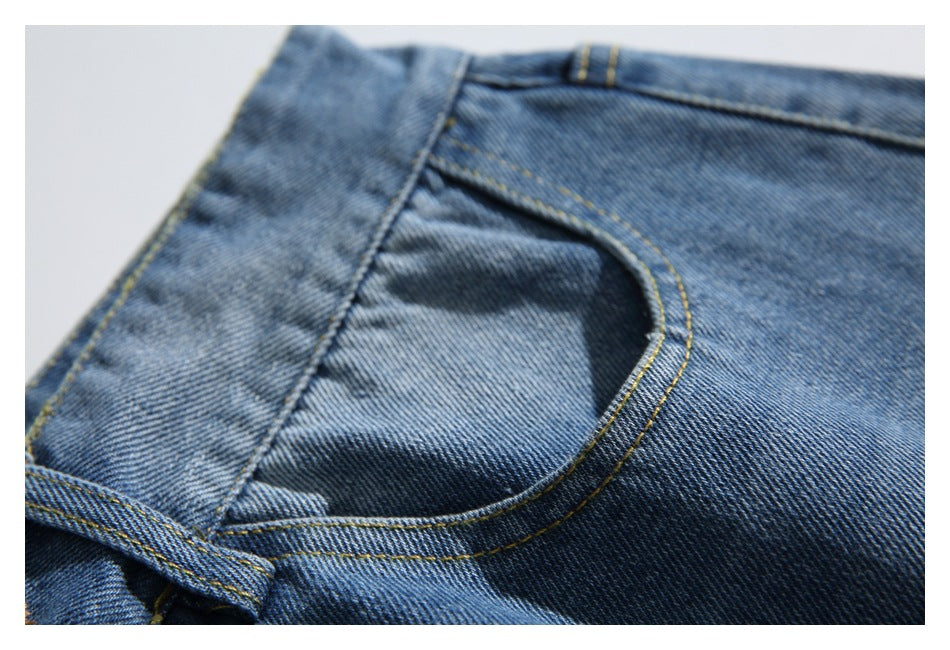 Close-up of a blue faded denim jeans front pocket with yellow stitching and a belt loop.