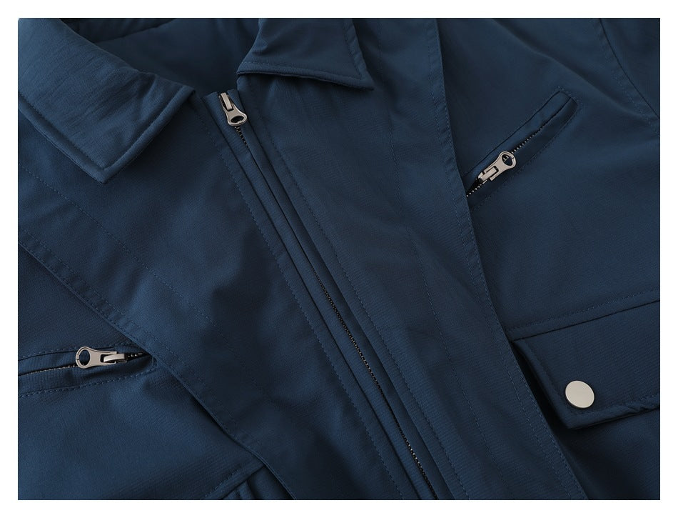 Close-up of a navy jacket showing the collar, front zipper, and several zippered pockets.