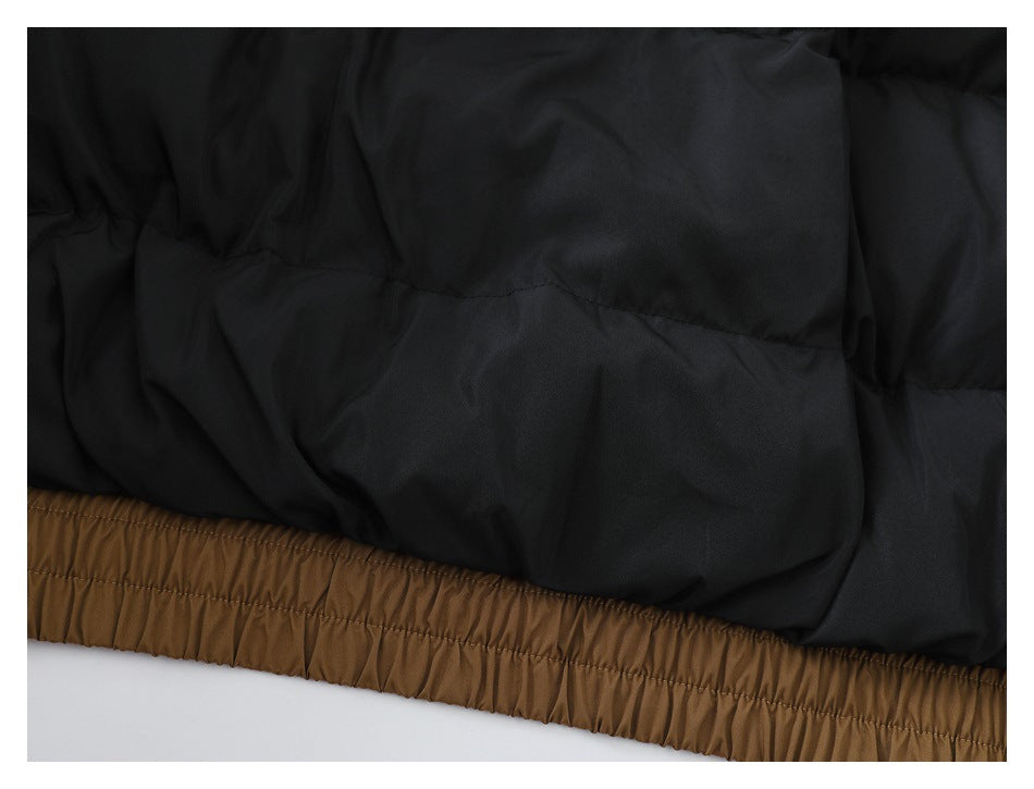 Close-up of black padded jacket fabric above a gathered brown elastic hem.