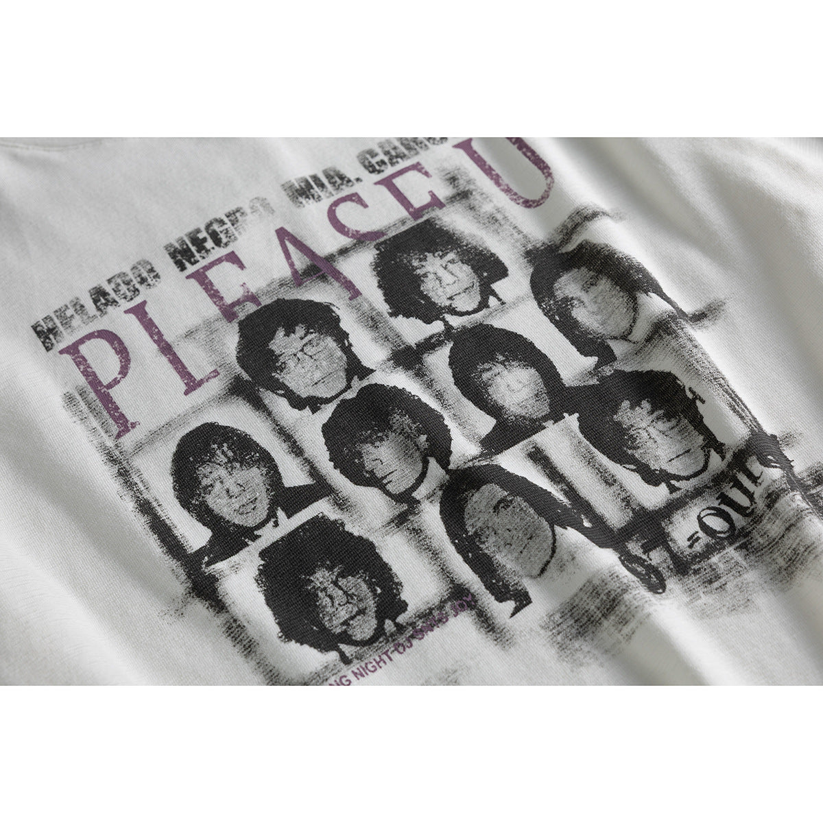 Close-up of a distressed black-and-gray portrait collage with large plum lettering printed on an off-white T-shirt.