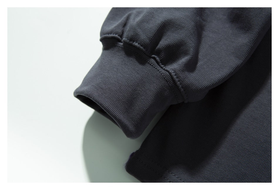 Close-up of a dark charcoal sleeve with a ribbed cuff and visible seam.