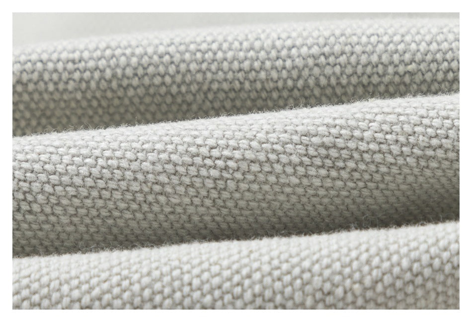 Extreme close-up showing the chunky woven texture of light gray fabric.