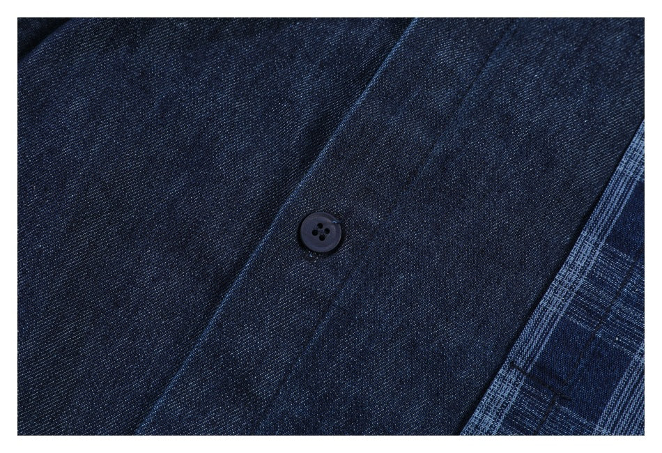 Close-up of a dark button on the solid navy front placket of a shirt, beside blue plaid fabric.