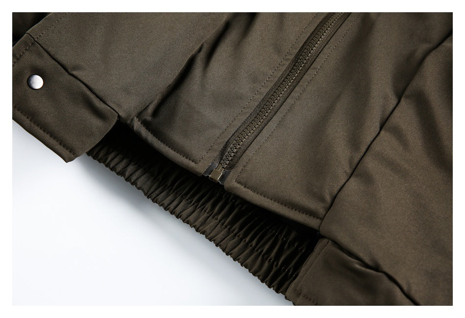 Close-up of an olive-brown jacket showing a diagonal zipper, snap cuff, and gathered elastic hem.