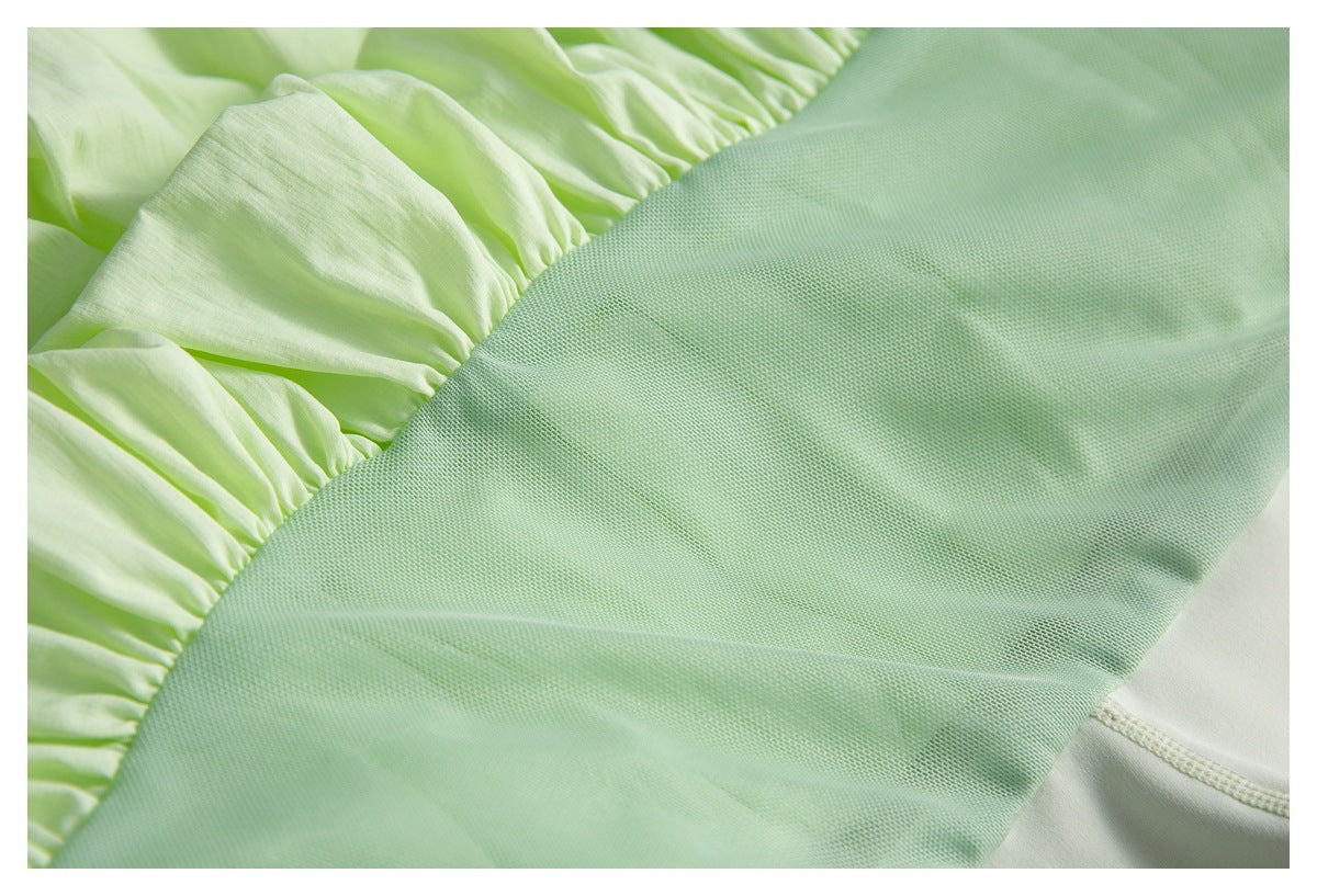 Close-up of light green mesh joined to gathered pale lime fabric on a mint garment.