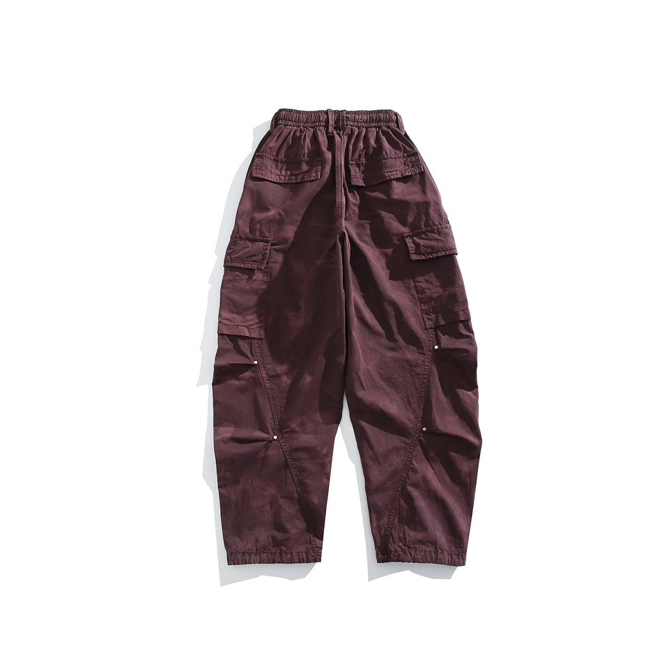 Back view of purple wide-leg cargo pants with elastic waist, flap pockets and rivet-accented side seams
