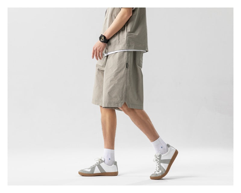 Side view of a cropped model wearing a taupe shirt and matching knee-length shorts.