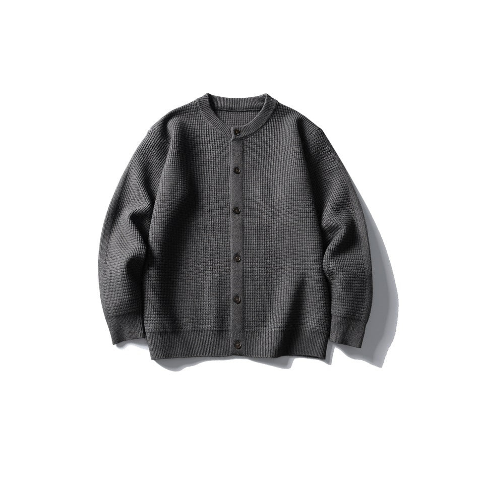 Dark gray waffle-knit button-front cardigan with round neckline and ribbed cuffs and hem, laid flat