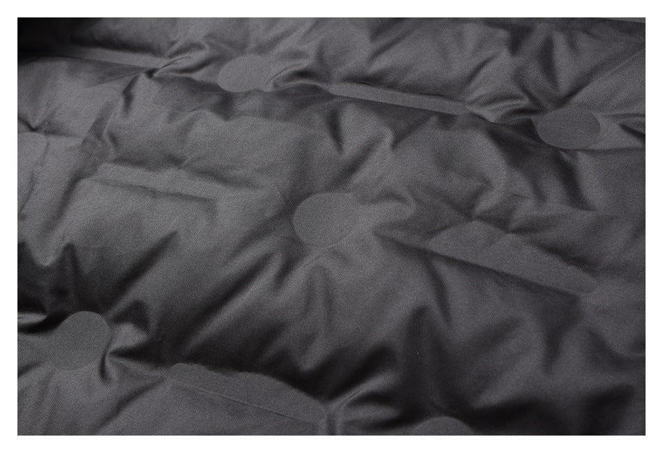 Close-up of dark gray padded lining with stitched channels and folds.