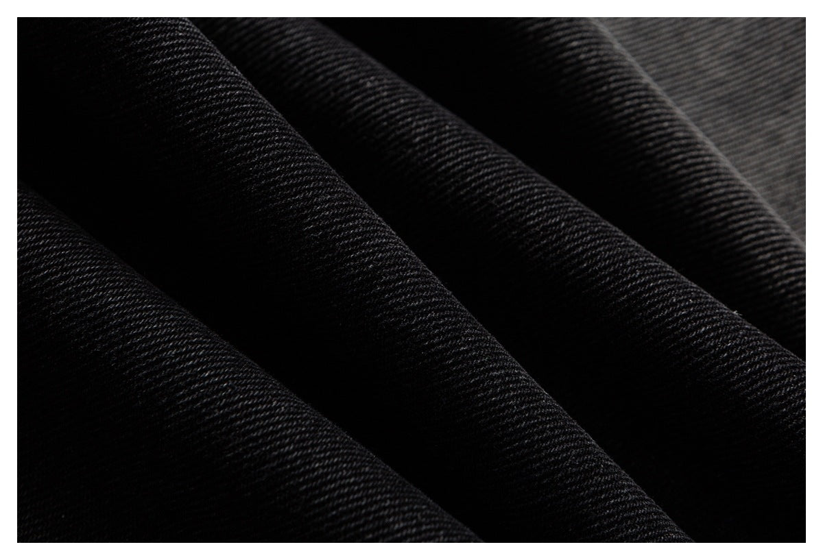 Macro view of the diagonal twill texture of black denim fabric.