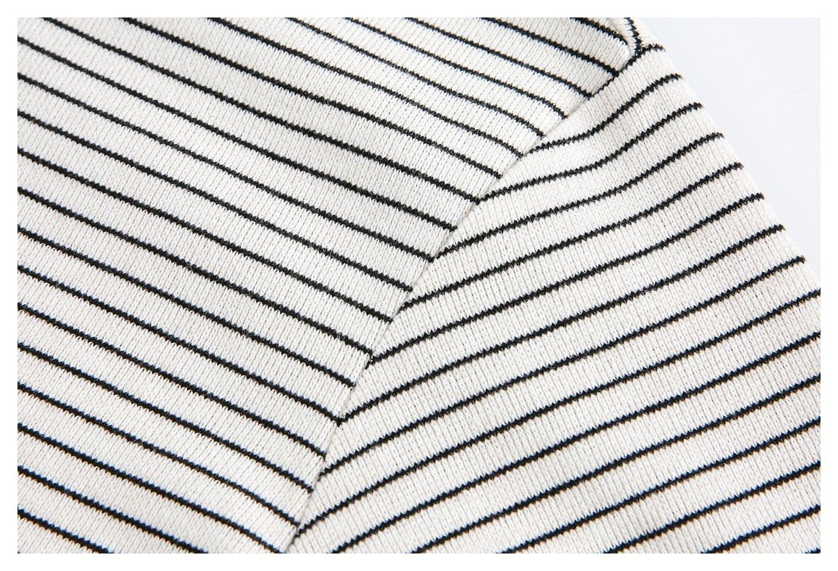 Close-up of the ivory T-shirt's black stripes across the shoulder and short sleeve seam.