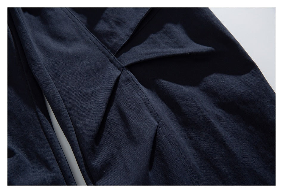 Close-up of intersecting stitched seams and panels on dark navy fabric.