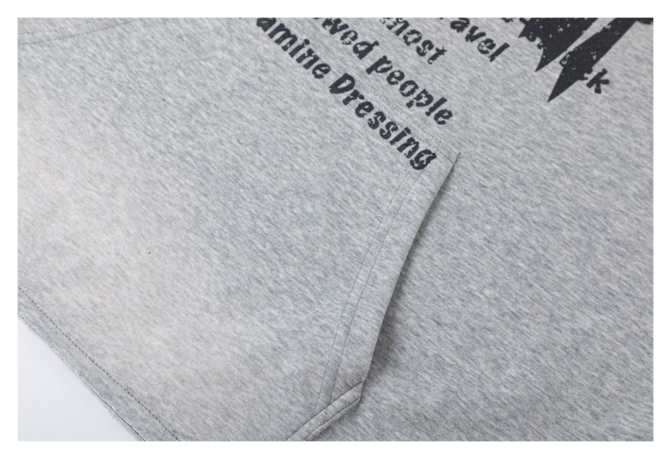 Close-up of a stitched seam on heather-gray fabric, with partial black English print near the edge.