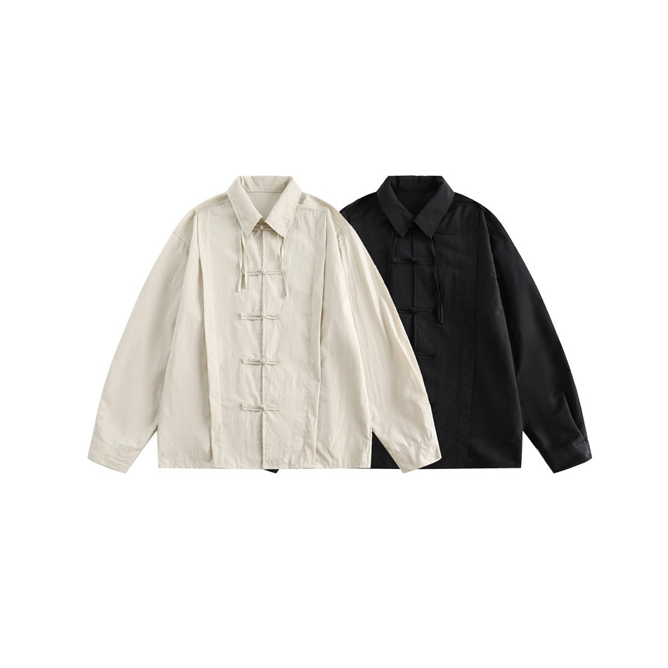 Two front-view shirts with collars and frog closures, shown in cream and black on a plain white background.