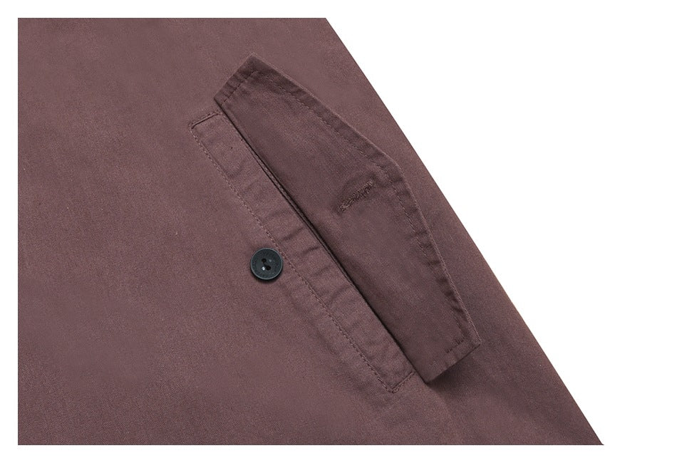 Close-up of a mauve-brown shirt's buttoned chest pocket and seam details on a white background.