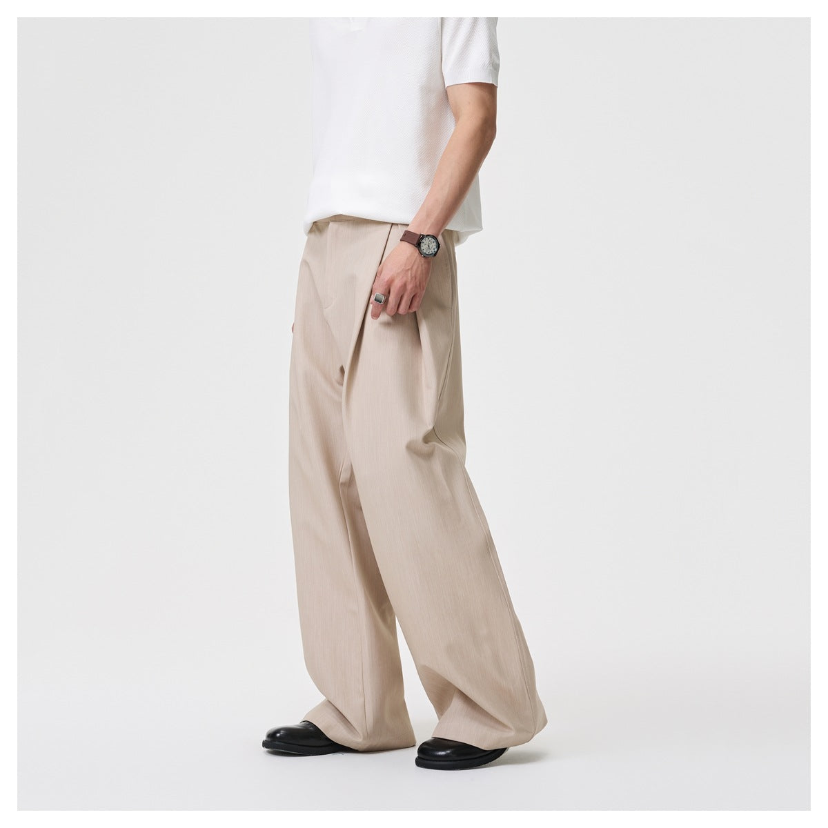Cropped model wearing beige wide-leg trousers with a white shirt, shown from a side angle.
