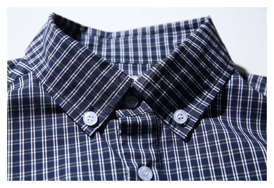 Close-up of a navy-and-white plaid shirt collar with white buttons.