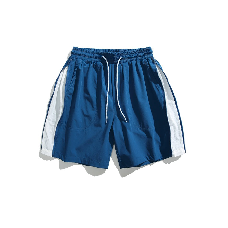 Blue shorts with white side panels, white drawcord and zippered side pockets, flat lay