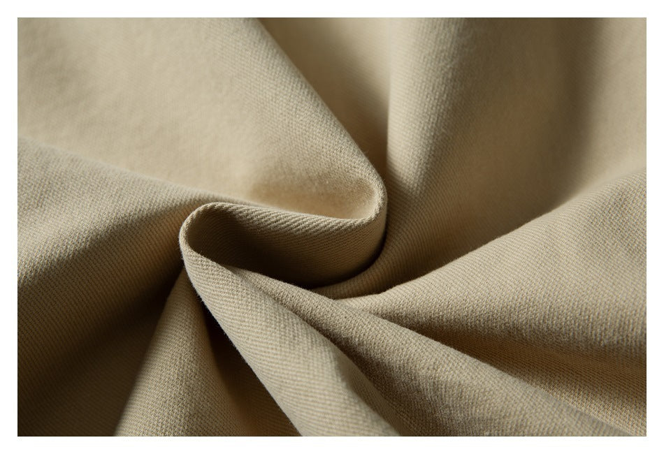 Close-up of beige jacket fabric draped to show its woven texture.