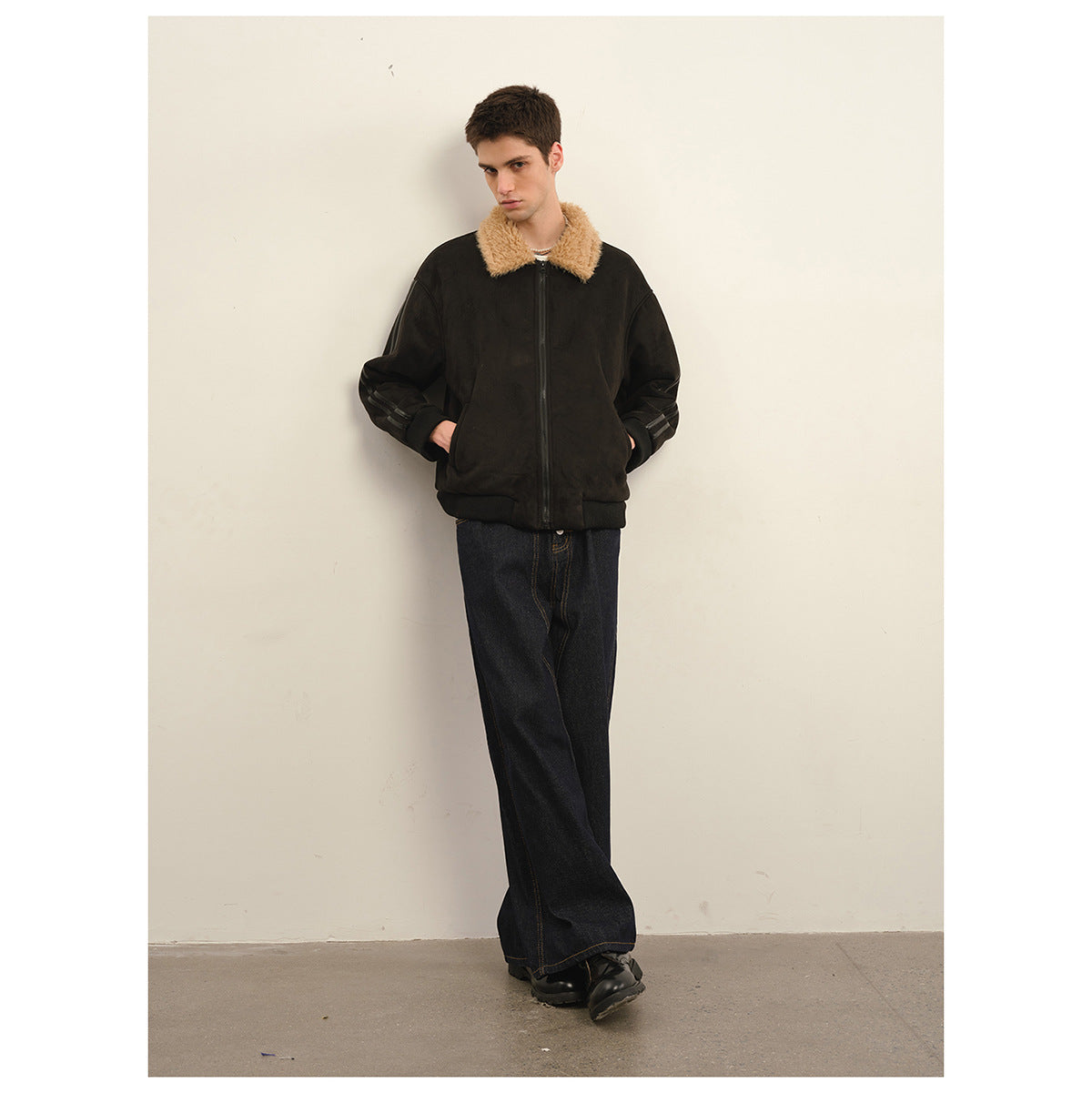 Front view of a model wearing a dark zip jacket with a tan plush collar and striped sleeves.