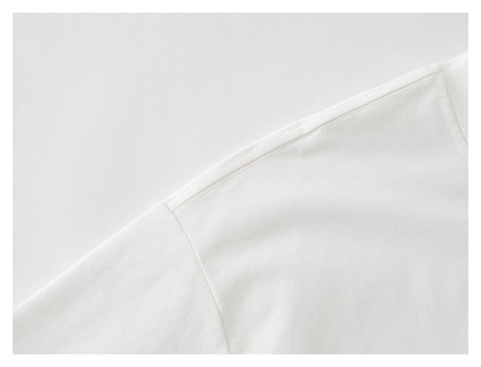 Close-up of the white T-shirt's shoulder seam and sleeve junction.
