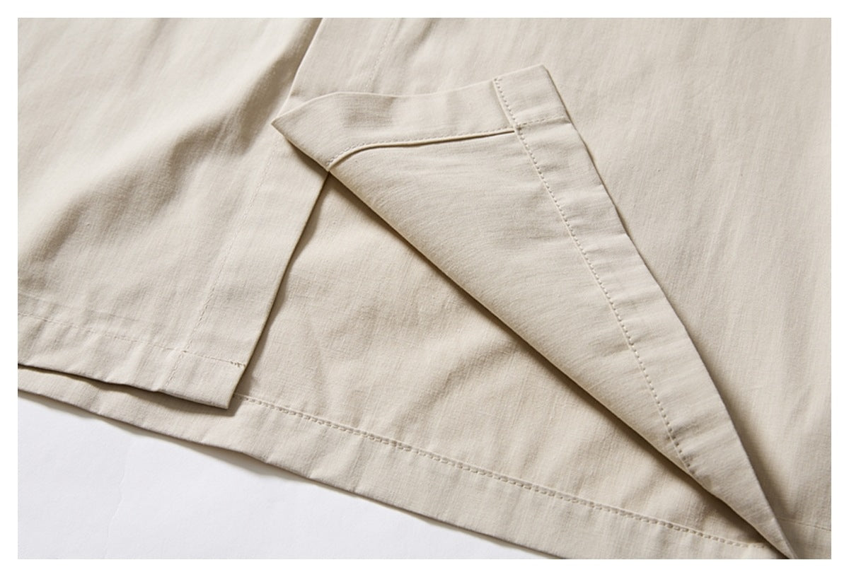 Close-up of an ivory shirt's side hem slit and overlapping hem panels.