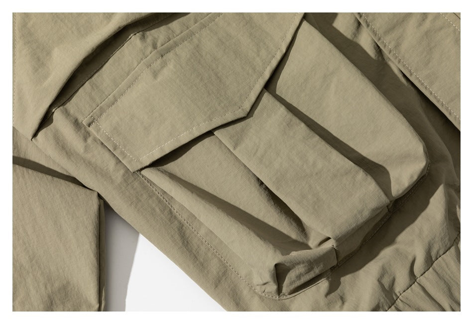 Close-up of a khaki jacket's large stitched flap pocket.