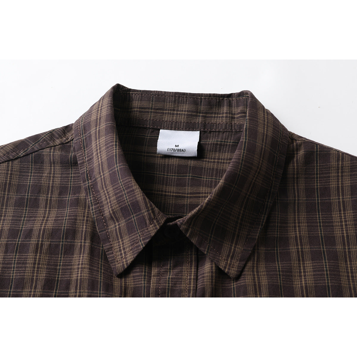 Close-up of a dark brown plaid shirt collar and inner size label marked M (170/88A).