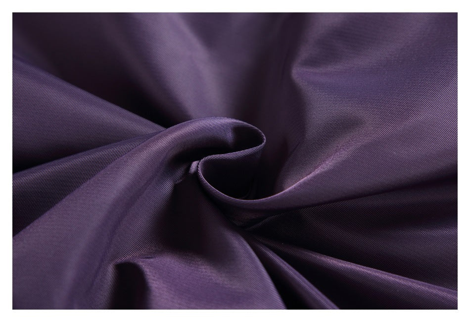 Close-up of dark purple fabric gathered to show its smooth surface and sheen.