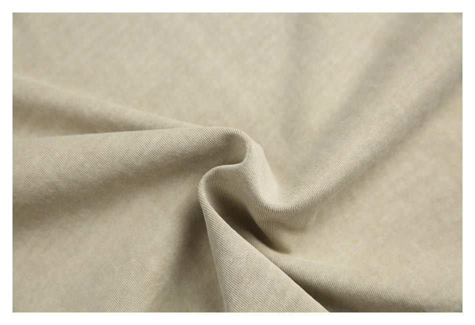 Close-up of softly folded beige fabric showing its fine surface texture.