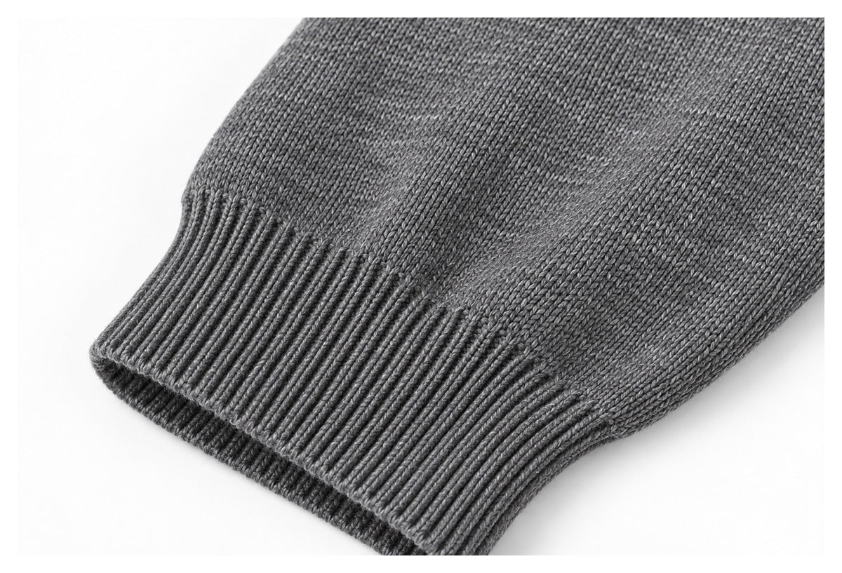 Close-up of a gray knit sleeve with a wide ribbed cuff against a white background.